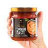 Hand holding a jar of Siam Thai Soup Tomyum Paste with a white background